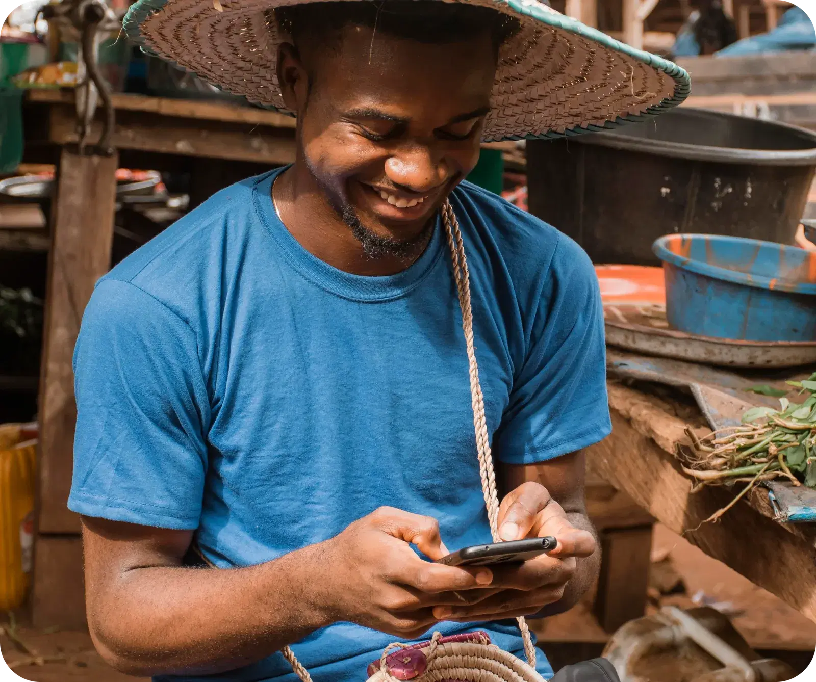A Routelink customer checking his phone at his market stall